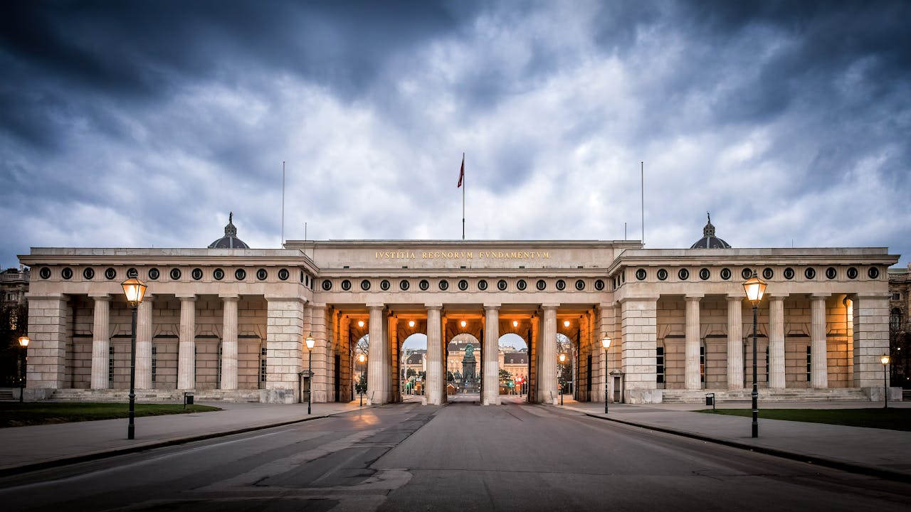 Classic architectural gate with columns under dramatic clouds, an iconic tourism landmark.